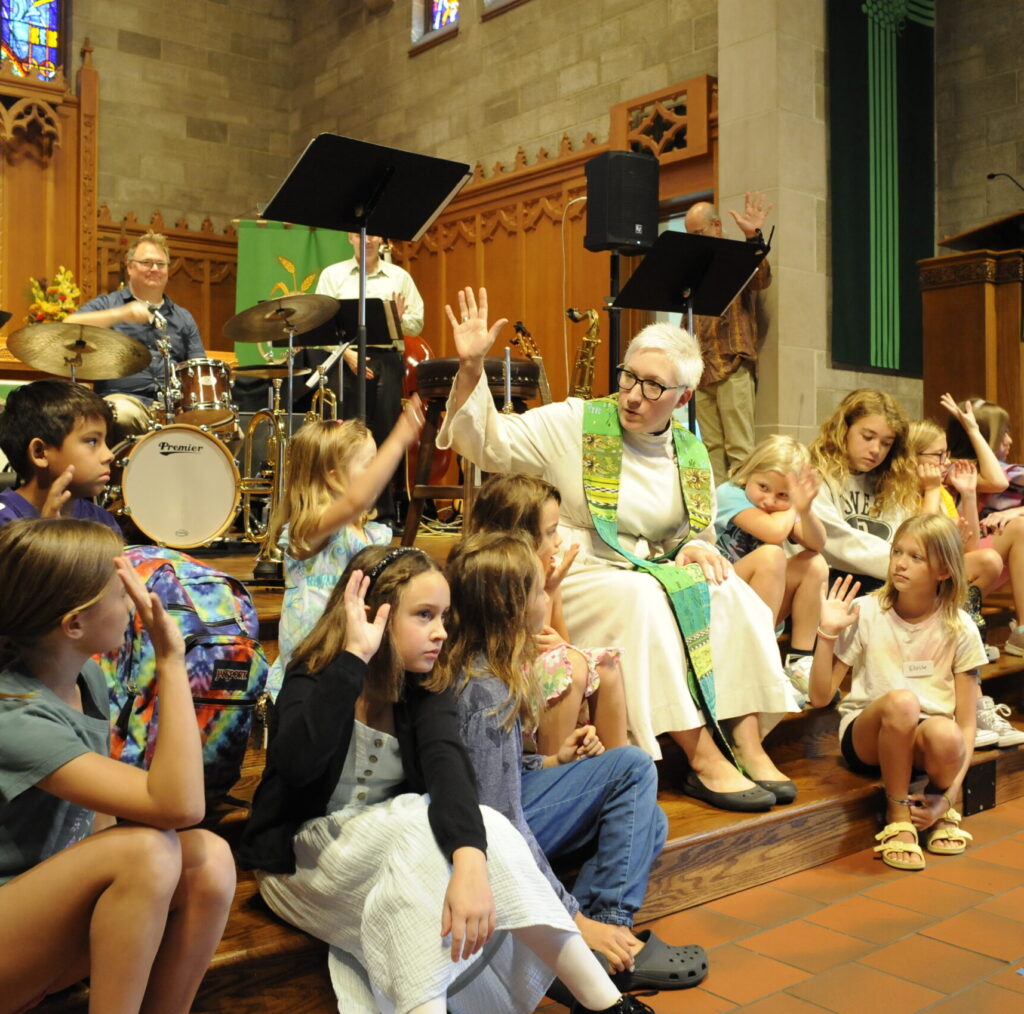 kids with pastor during worship